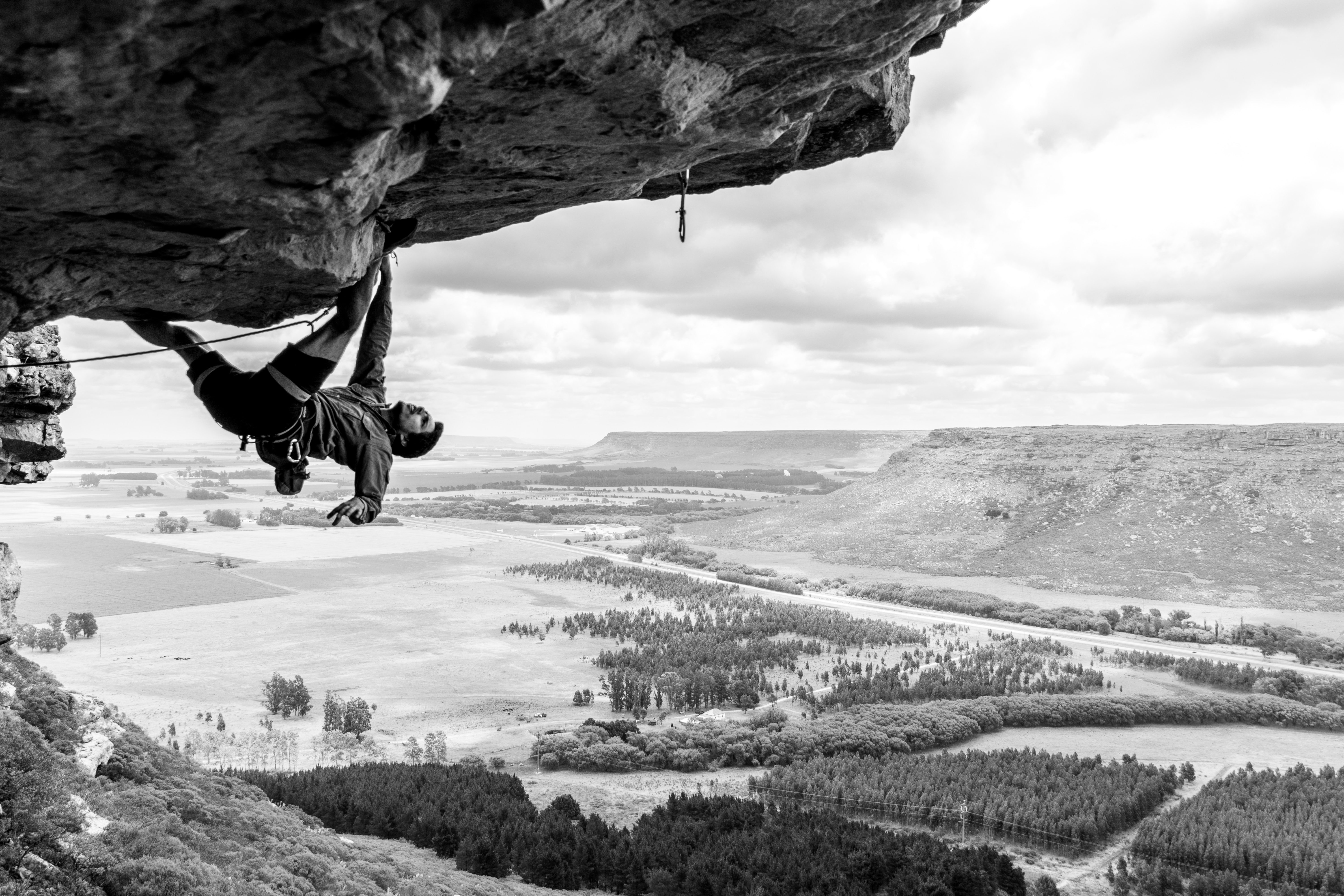 climber on steep overhang in black and white